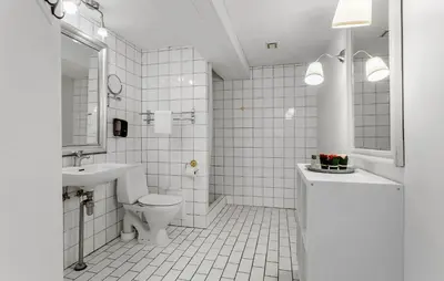 a white bathroom with a toilet and a sink at Lejl 7 in Brovst