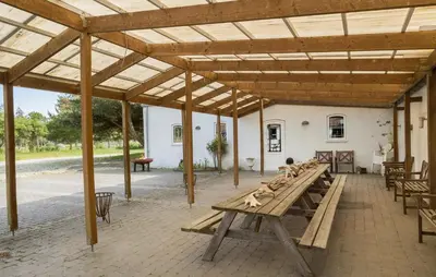 a pavilion with a wooden table and chairs at Røgegård Gården in Fjerritslev