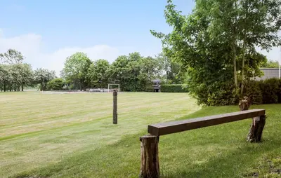 a wooden bench in a field with a soccer field at Lovely Apartment In Erslev With Wifi in Erslev