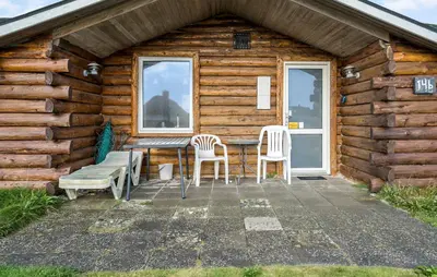 a wooden cabin with a table and chairs outside at Gorgeous Home In Harboøre With Kitchen in Harboør