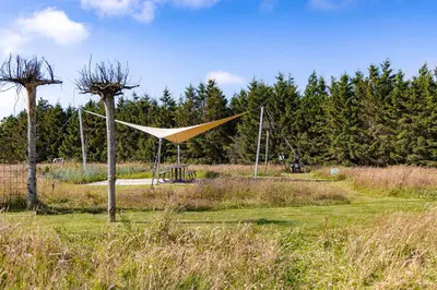 a tent in a field with trees in the background at Fun Art Blokhus in Blokhus