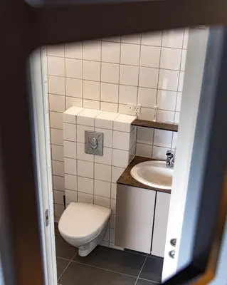 a small bathroom with a toilet and a sink at Fun Art Blokhus in Blokhus