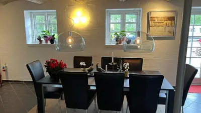 a dining room with a table and chairs at Staudeengen et dejlig sted med fred og ro in Ålestrup