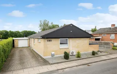 a house with a black roof on a street at Amazing Home In Aars With Wifi in Års