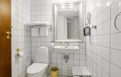 a white bathroom with a toilet and a sink at Lejl 6 in Brovst
