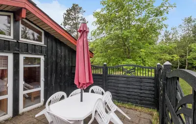 a patio with a table and chairs and an umbrella at Stunning Home In Brovst With Sauna in Brovst