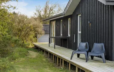 two blue chairs sitting on a wooden deck next to a house at Awesome Home In Løgstør With Wifi in Løgstør