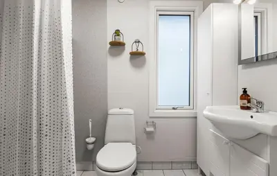 a white bathroom with a toilet and a sink at Awesome Home In Løgstør With Wifi in Løgstør