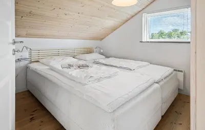 a white bed in a room with a window at Cozy Home In Harboøre in Harboør