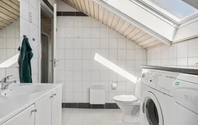 a white bathroom with a washing machine in it at Cozy Home In Harboøre in Harboør