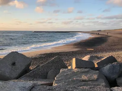 a beach with rocks on the sand and the ocean at 5 star holiday home in Vestervig-By Traum in Vestervig