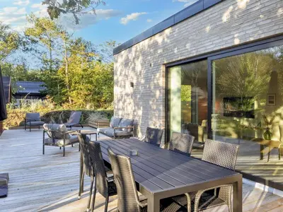 a wooden table and chairs on a wooden deck at 5 star holiday home in Vestervig-By Traum in Vestervig