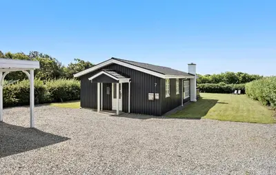 a black house with a gravel driveway in front of it at Lovely Home In Vestervig With Kitchen in Vestervig