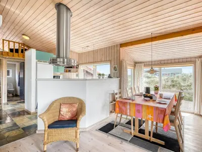 a kitchen and dining room with a table and chairs at Holiday Home Hughe - 200m from the sea by Interhome in Frøstrup