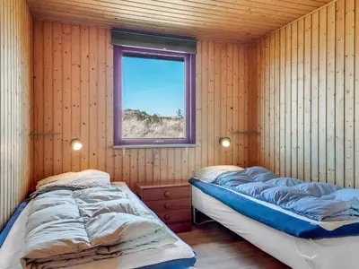 two beds in a room with a window at Holiday Home Frandsine - 1-2km from the sea by Interhome in Thisted