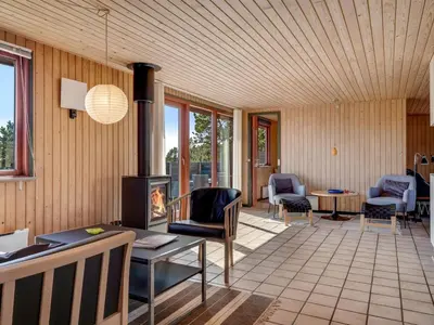 a living room with a fireplace and a table and chairs at Holiday Home Frandsine - 1-2km from the sea by Interhome in Thisted