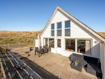 a house with a patio with a table and chairs at Holiday Home Luzy - 75m from the sea by Interhome in Harboør