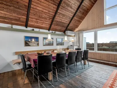 a dining room with a table and chairs and windows at Holiday Home Luzy - 75m from the sea by Interhome in Harboør
