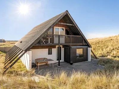 a house with a thatched roof and a patio at Holiday Home Luzy - 75m from the sea by Interhome in Harboør