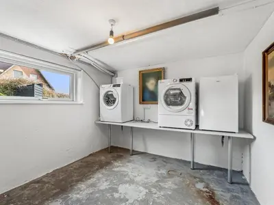 a laundry room with two washing machines on a shelf at Holiday Home Hilppa - 400m from the sea by Interhome in Harboør