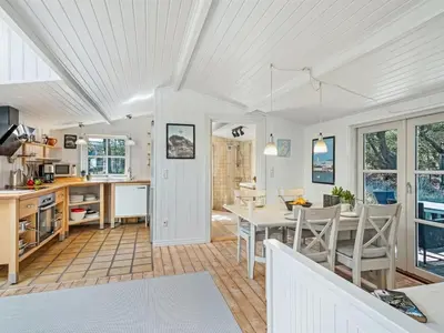 a kitchen and dining room with a table and chairs at Holiday Home Hellena - 700m from the sea by Interhome in Torsted