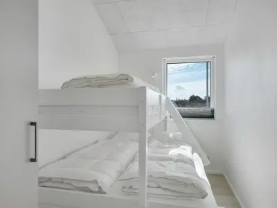 a white bunk bed in a white room with a window at Holiday Home Helga - 650m from the sea by Interhome in Torsted