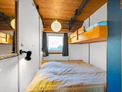 a bedroom with a bed in a tiny house at Holiday Home Kurt - 75m from the sea by Interhome in Harboør
