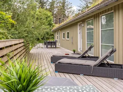 a deck with two chairs and a table on a house at Holiday Home Yngve - 1-2km from the sea by Interhome in Løkken