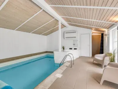 a swimming pool in a room with a tub at Holiday Home Yngve - 1-2km from the sea by Interhome in Løkken