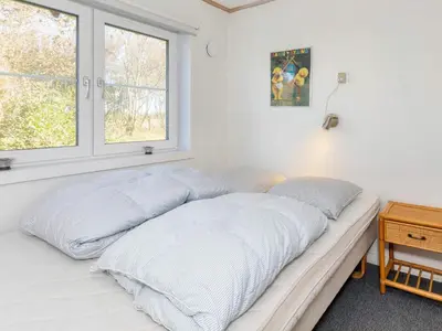 a bed with white sheets in a room with a window at Scenic Pool House Retreat - By Traum Ferienwohnungen in Thyholm