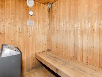 a wooden sauna with a trash can and a clock at Scenic Pool House Retreat - By Traum Ferienwohnungen in Thyholm