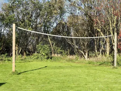 a volley ball net in a field with trees at Scenic Pool House Retreat - By Traum Ferienwohnungen in Thyholm