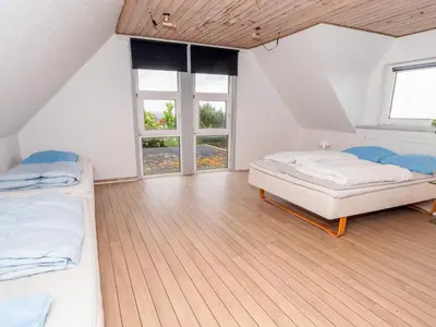 a attic bedroom with two beds and a window at Family Fun with Fjord View - By Traum Ferienwohnungen in Thyholm