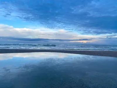 a reflection of the sky in the water on the beach at 8 person holiday home in Pandrup-By Traum in Pandrup