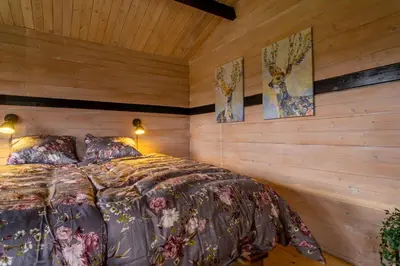 a bedroom with a bed in a wooden wall at Hedelandets Camping in Sevel