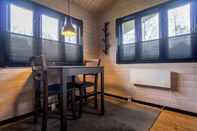 a dining room with a table and chairs and windows at Hedelandets Camping in Sevel