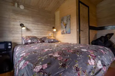 a bedroom with a large bed with flowers on it at Hedelandets Camping in Sevel
