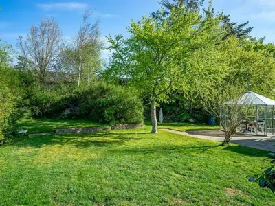 a garden with a tree and a gazebo at Holiday Home Satu - 2km from the sea by Interhome in Blokhus