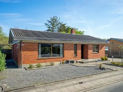 a brick house with a solar roof at Holiday Home Satu - 2km from the sea by Interhome in Blokhus