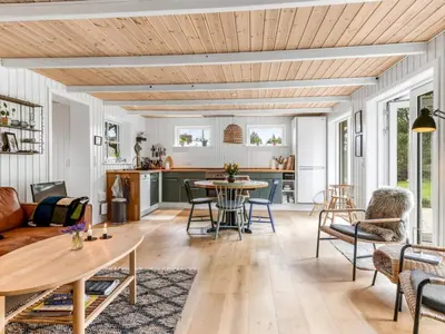 a living room with a table and chairs at Holiday Home Jenvold - 1-5km from the sea by Interhome in Blokhus