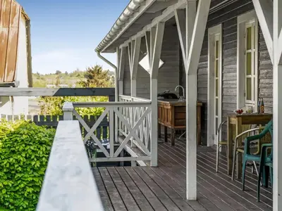a porch with a table and a kitchen on a house at Holiday Home Ejnarine - 600m to the fjord by Interhome in Farsø