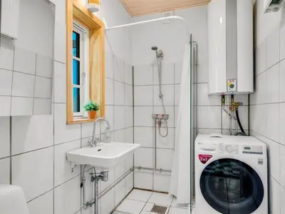 a bathroom with a washing machine and a sink at Holiday Home Ejnarine - 600m to the fjord by Interhome in Farsø