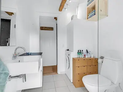 a white bathroom with a toilet and a sink at Holiday Home Amarie - 1km from the sea by Interhome in Pandrup