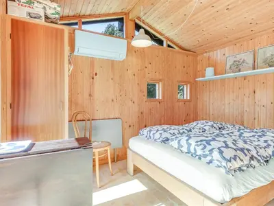a bedroom with a bed and a wooden wall at Holiday Home Amarie - 1km from the sea by Interhome in Pandrup