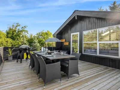 a patio with a table and chairs on a deck at Holiday Home Ema - 1-9km from the sea by Interhome in Saltum