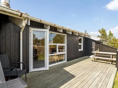 a wooden deck with a bench on a house at Holiday Home Elisenda - 1km from the sea by Interhome in Torsted