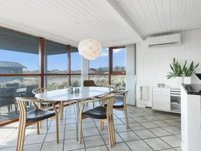 a dining room with a white table and chairs at Holiday Home Lilie - 350m from the sea by Interhome in Saltum