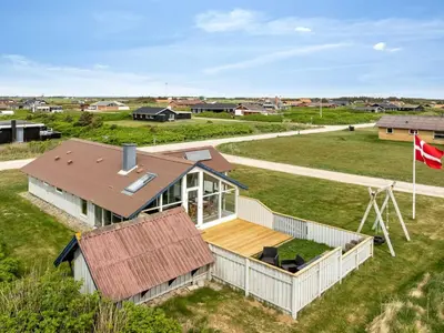an aerial view of a house with a flag at Holiday Home Emppu - 250m from the sea by Interhome in Harboør