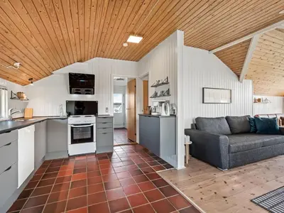 a kitchen and living room with a couch in a room at Holiday Home Emppu - 250m from the sea by Interhome in Harboør