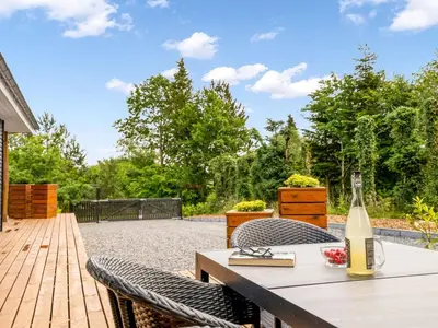 a bottle of wine sitting on a table on a patio at Holiday Home Skip - 300m to the fjord by Interhome in Højslev